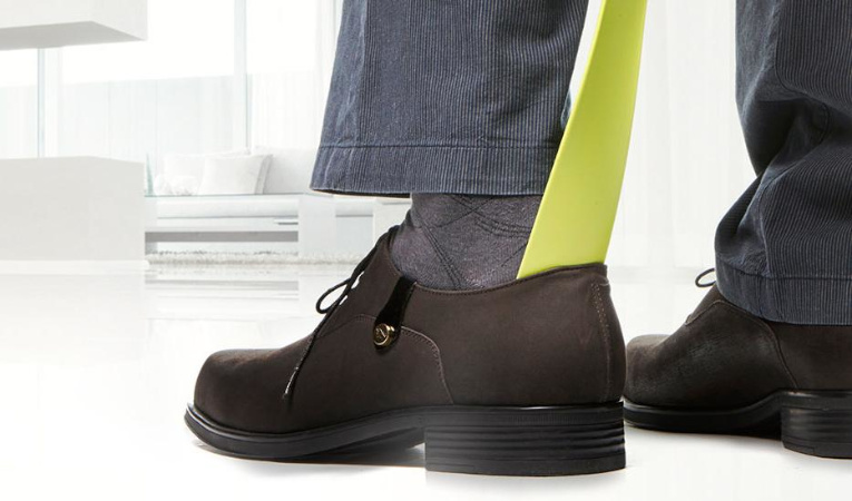 Человек надевает ботинки